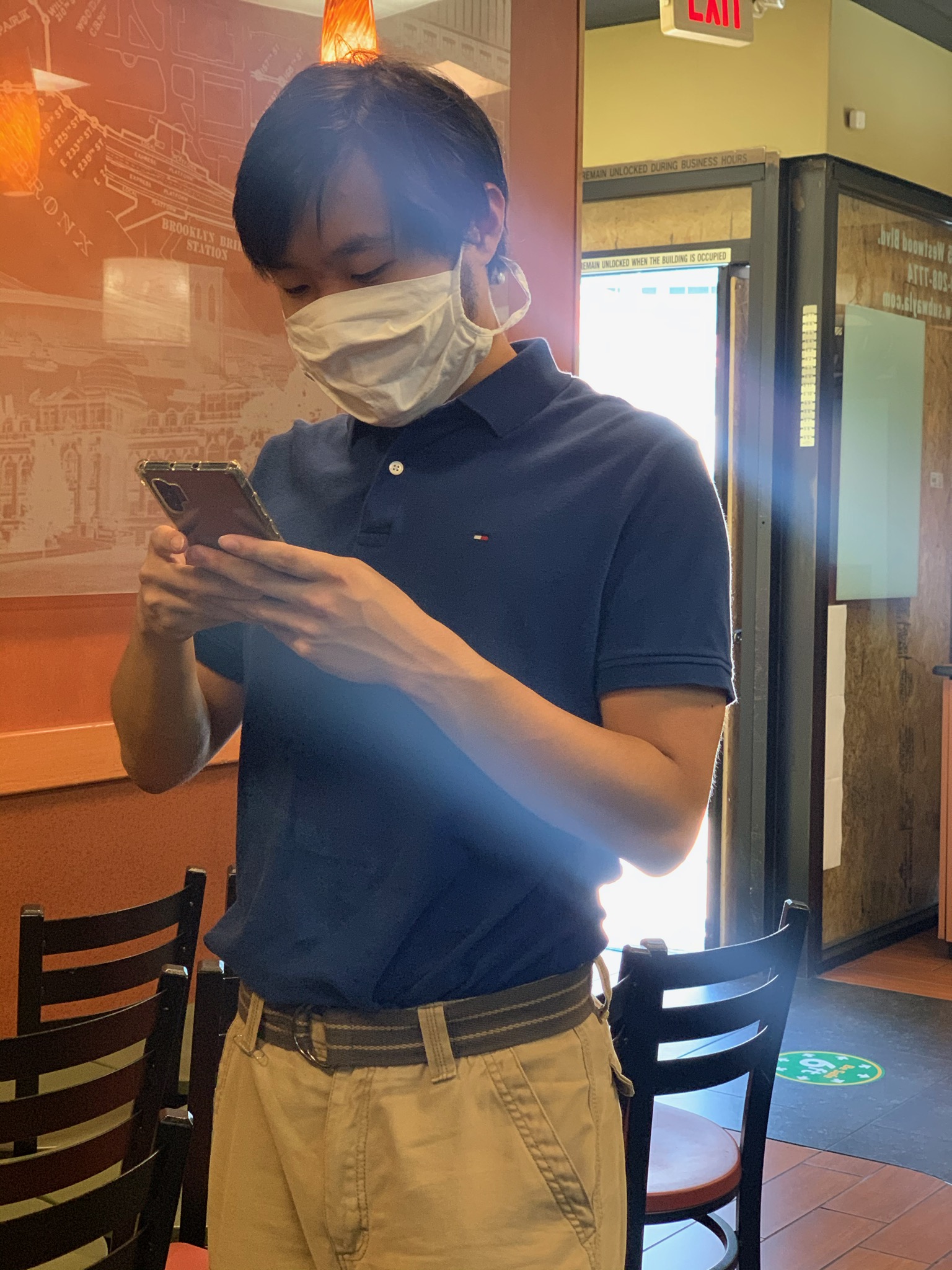 brian looking at his phone in front of subway door